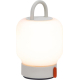 Lampe portable allumée sur fond uni, avec base grise et bouton orange sur le côté, sans personnalisation visible.
