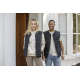 Gilet matelassé noir porté par une femme et un homme, présenté en extérieur. Aucune personnalisation visible. Gilet matelassé noir porté par une femme et un homme, présenté en extérieur. Aucune personnalisation visible.