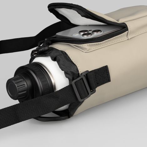 Sac beige couché sur le côté avec gourde visible à l’intérieur. Sac beige couché sur le côté avec gourde visible à l’intérieur.