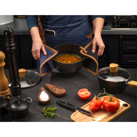 Vue en situation d’une personne utilisant deux maniques assorties pour tenir une casserole chaude, sans marquage visible.
