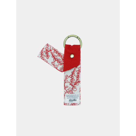 Porte-clés bicolore rouge/verso blanc à motif rouge, anneau doré, marquage au dos en bas.