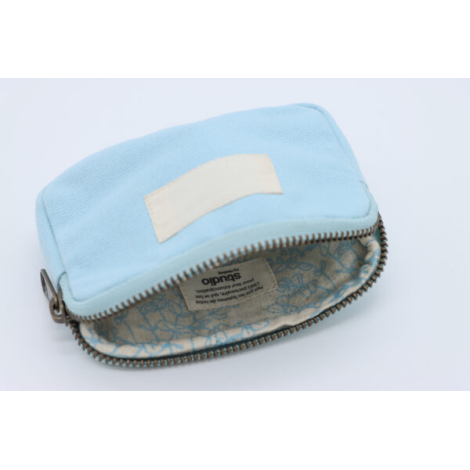 Petite trousse bleue claire ouverte avec zip métallique et doublure à motif clair.
