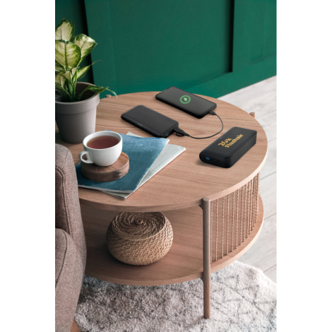 Batterie utilisée sur une table basse, connectée à plusieurs téléphones en charge, sans marquage visible.