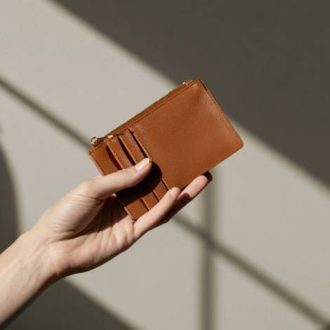 Porte-monnaie en PU camel tenu en main, illustrant sa texture lisse et son format fin, présenté sans personnalisation.