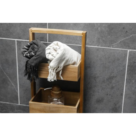 Deux foutas recyclées, noir et blanc, roulées et déposées sur une étagère en bois dans une salle de bain, laissant voir la textu