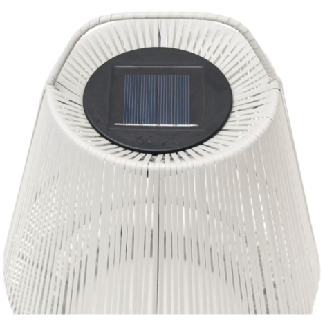 Gros plan sur la partie supérieure d’un abat-jour portable ajouré, montrant le panneau solaire intégré au centre de la structure