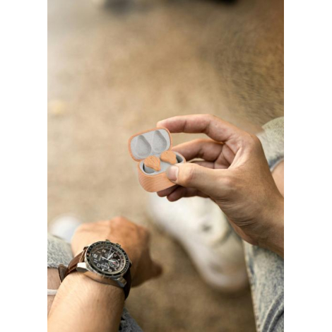 Boîtier ouvert tenu dans une main, montrant les écouteurs en place ; marquage visible sur la face avant ; scène illustrant un us