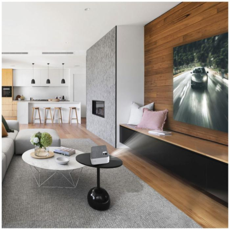 Projecteur en fonctionnement posé sur une table basse dans un salon, projetant une image sur un panneau mural, sans marquage app