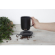 Mug noir tenu dans une main, positionné au-dessus de son support de charge, écran LED actif indiquant une température ; marquage
