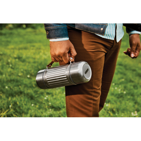 Gourde Explorer Duo transportée horizontalement en extérieur grâce à sa sangle solide, design résistant et parois isolantes mise