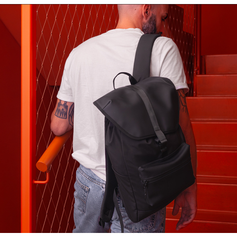 Vue arrière d’un homme portant le sac noir avec rabat fermé et bretelle visible, sans marquage apparent sur cette vue.