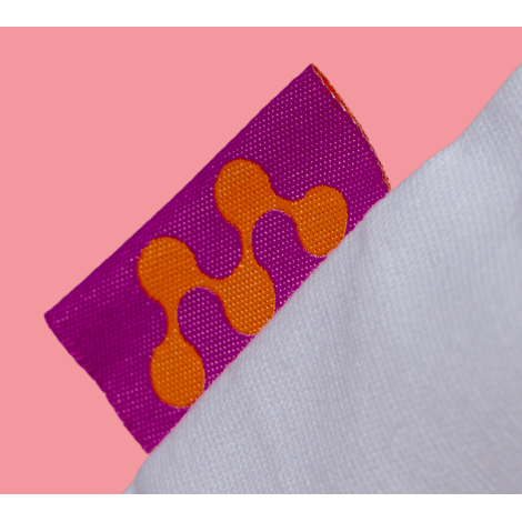 Vue rapprochée d’une petite étiquette tissée rectangulaire fixée sur le bord du sac, présentant un motif coloré, sans personnali