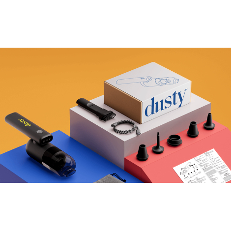 Vue d’ensemble du coffret comprenant l’aspirateur noir, plusieurs embouts interchangeables, un câble torsadé, une boîte illustré