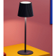 Vue de trois quarts d’une lampe noire posée sur une surface colorée, montrant abat-jour plissé et base circulaire avec marquage 