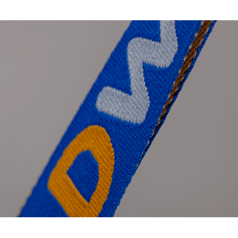 Vue rapprochée d’une anse jacquard bleue présentant une texture tissée et un motif multicolore, sans personnalisation visible.