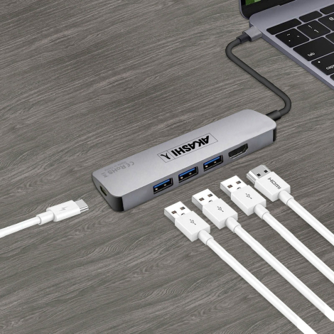 Hub USB-C gris connecté à ordinateur portable sur surface bois avec marquage