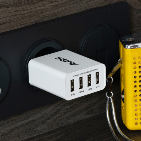 Chargeur blanc branché à prise murale avec quatre ports USB en façade