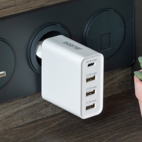 Chargeur blanc branché à prise murale avec ports USB-C et USB-A et marquage sur le dessus