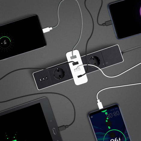 Chargeur blanc branché à multiprise relié à plusieurs appareils électroniques