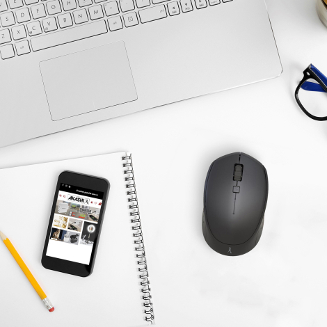 Souris noire vue de dessus sur bureau blanc avec ordinateur et accessoires