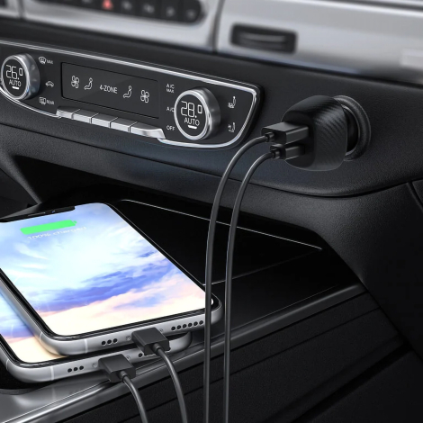 Chargeur allume-cigare branché avec deux câbles dans la console d’un véhicule, smartphone fixé à proximité