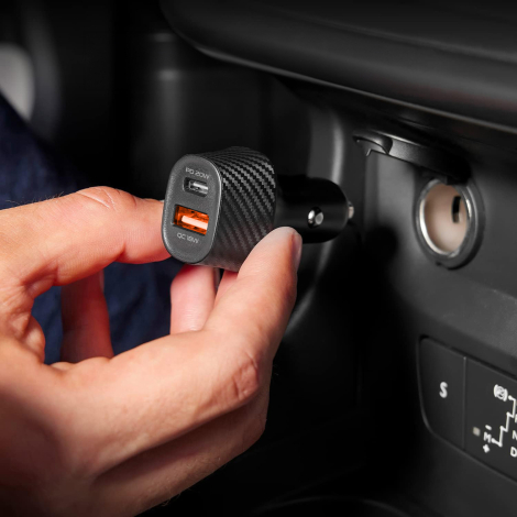 Chargeur allume-cigare branché dans un espace central avec câble et smartphone à proximité