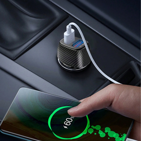 Chargeur allume-cigare noir tenu en main devant une prise de tableau de bord