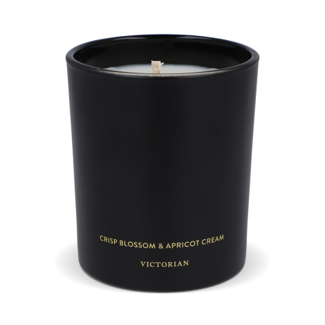 Bougie noire vue de trois quarts avec cire claire et mèche centrale, sans marquage visible.