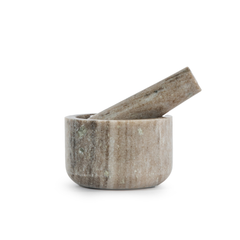 Mortier et pilon en travertin vus de côté avec pilon incliné dans le bol, sans marquage visible.