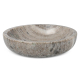 Bol en marbre travertin vu sous un angle bas, montrant son intérieur creusé et son rebord arrondi, sans marquage visible.