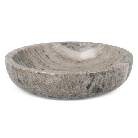 Bol en marbre travertin vu sous un angle bas, montrant son intérieur creusé et son rebord arrondi, sans marquage visible.