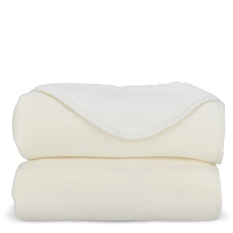 Couverture blanche pliée montrant la face pelucheuse contrastant avec la face lisse, sans marquage apparent.