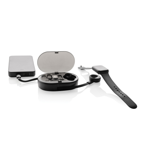 Boîtier de recharge noir ouvert sur fond blanc, relié par un câble à une batterie externe, avec montre connectée posée à droite 