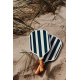 Deux raquettes de pickleball à motif rayé bleu et blanc posées sur le sable avec une balle, dans un environnement extérieur, les