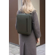 Sac porté sur le dos par une femme en environnement urbain, de couleur vert foncé, avec fermeture zippée verticale visible sur l