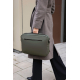 Sac porté à la main par une femme en environnement urbain, de couleur vert foncé, avec poignée supérieure et poche zippée horizo