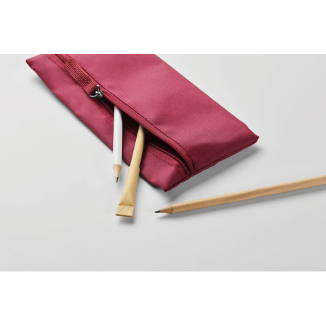 Vue d’une trousse à crayons partiellement ouverte sur surface claire, laissant apparaître des crayons rangés à l’intérieur et le