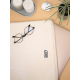 Housse ordinateur promotionnelle en velours coton bio beige format M 15 pouces en situation sur bureau, avec personnalisation ap