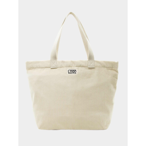 Sac cabas beige clair photographié de face avec anses longues assorties et étiquette rectangulaire centrée, marquage apparent su