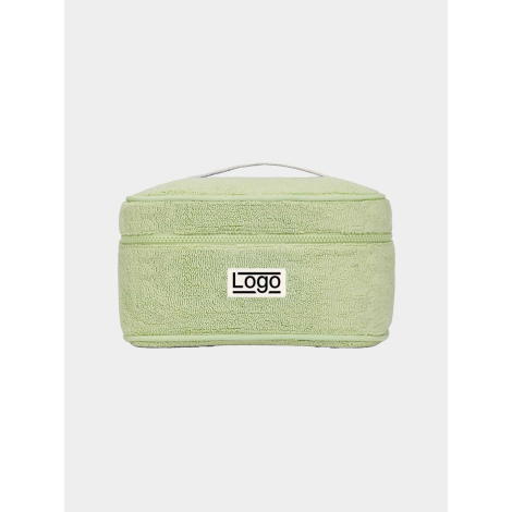 Vanity rectangulaire souple vert clair, vue de face sur fond neutre, avec poignée sur le dessus et fermeture zippée horizontale,