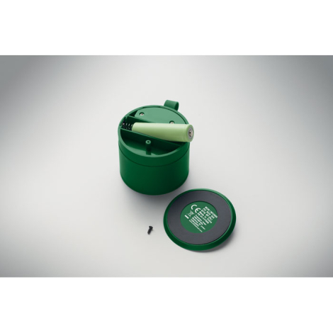 Vue interne d’un haut-parleur sans fil vert présenté ouvert, laissant apparaître la batterie cylindrique amovible avec le couver