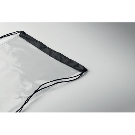 Détail de l’angle supérieur d’un sac à cordon transparent montrant la matière translucide, la bande de finition noire et le pass