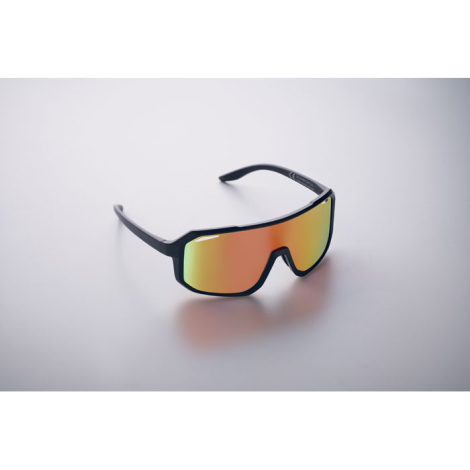 Lunettes de sport posées sur une surface claire, vues de face et légèrement de côté, avec écran miroir aux reflets orangés, sans