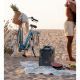Sac à dos isotherme posé sur une plage à côté d’un vélo et d’une personne, face avant visible avec personnalisation apparente su Sac à dos isotherme posé sur une plage à côté d’un vélo et d’une personne, face avant visible avec personnalisation apparente su