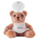 Présenté assis de face sur fond blanc, un ours en peluche habillé en chef cuisinier avec toque et tablier blancs, éléments du vi Présenté assis de face sur fond blanc, un ours en peluche habillé en chef cuisinier avec toque et tablier blancs, éléments du vi