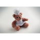 Vue en légère perspective d’un ours en peluche chef cuisinier assis sur fond clair, portant une toque et un tablier blancs, sans Vue en légère perspective d’un ours en peluche chef cuisinier assis sur fond clair, portant une toque et un tablier blancs, sans