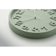En gros plan et en légère perspective, une horloge murale ronde vert clair met en évidence les chiffres en relief et les aiguill En gros plan et en légère perspective, une horloge murale ronde vert clair met en évidence les chiffres en relief et les aiguill