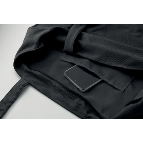 ue intérieure d’un sac shopping en velours côtelé montrant l’ouverture zippée, la doublure et une poche intérieure avec un objet