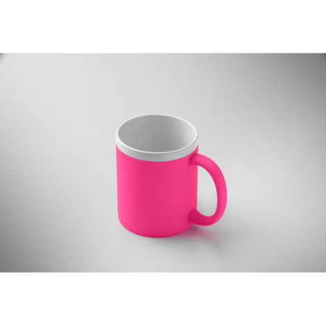 Mug en céramique rose présenté en légère perspective sur fond neutre avec extérieur mat, intérieur blanc et anse visible, sans m