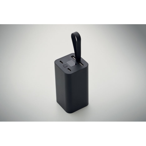 Powerbank présentée seule en vue de trois-quarts sur fond neutre avec sangle en silicone relevée, sans personnalisation visible.